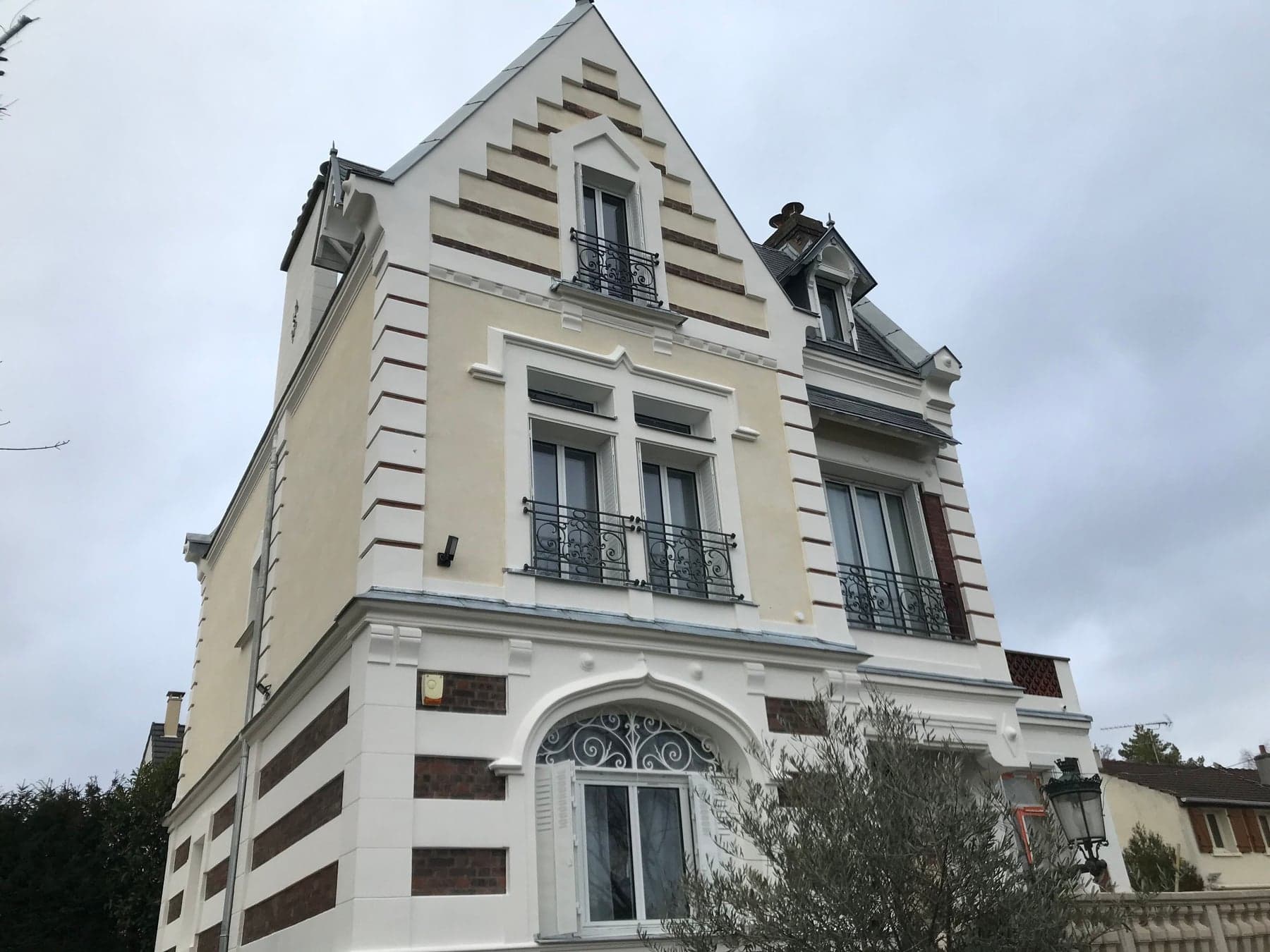 Villa rénovée vue d’angle, bandeaux de brique et pignon décoratif