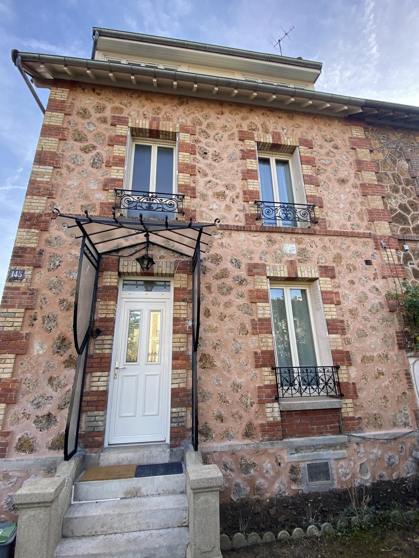Détail de façade en meulière avec joints à la chaux et encadrements de briques