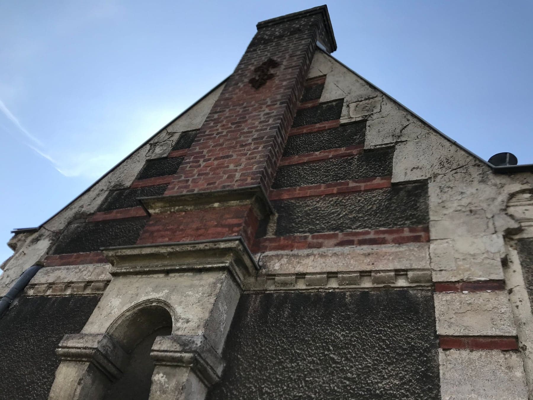 Pignon de maison ancienne avant ravalement, brique et enduit encrassés
