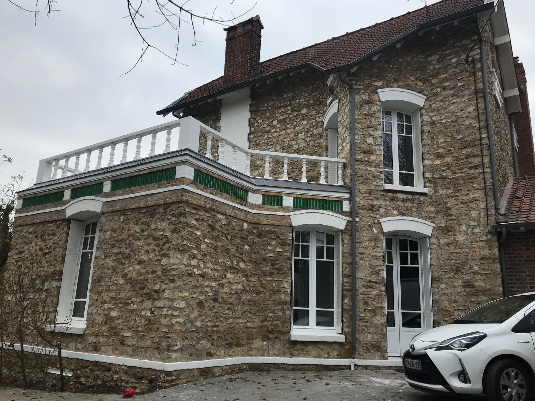 Maison en pierre meulière rénovée, terrasse et menuiseries blanches